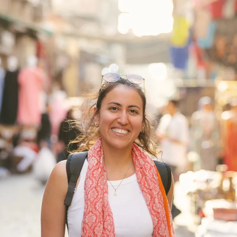 Viajante sorrindo em meio a uma movimentada feira marroquina